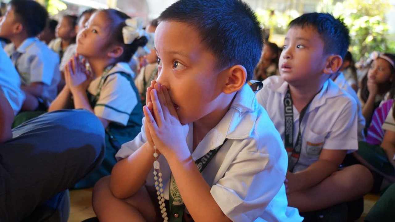 bambino che prega il rosario