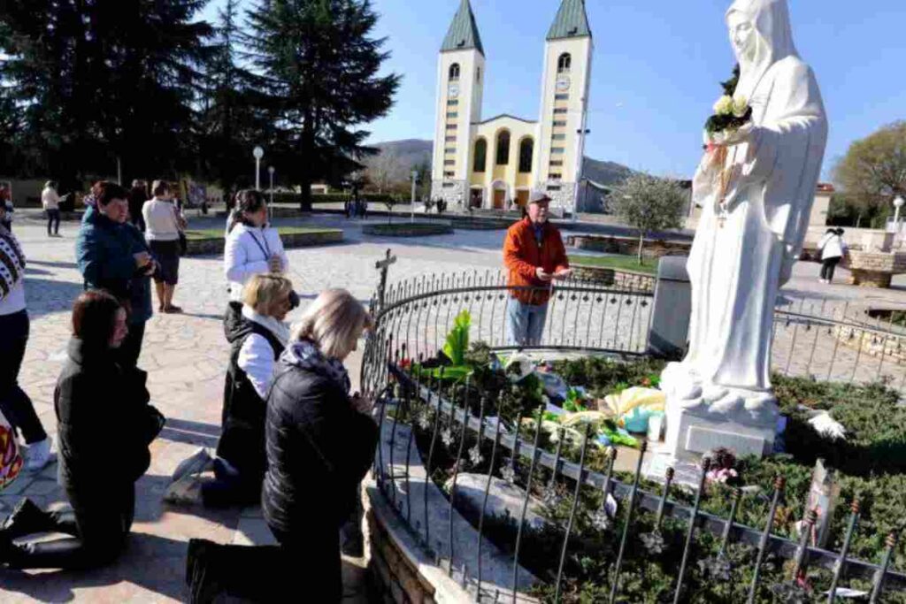 Pellegrini pregano davanti alla statua della Madonna a Medjugorje